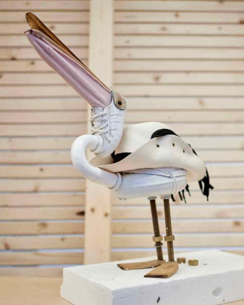 Pelican sculpture consisting of, among other things, a cowboy hat, a baby sneaker and shoe spoons