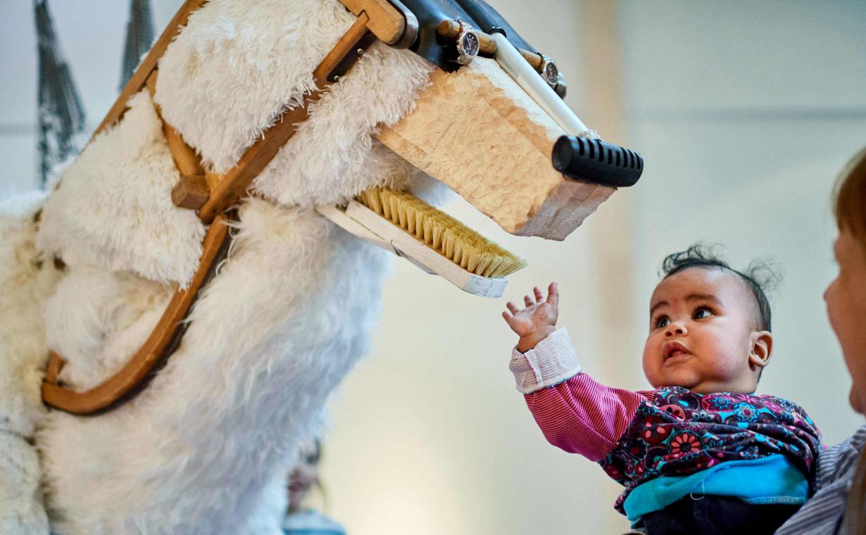 small child stretches towards the polar bear