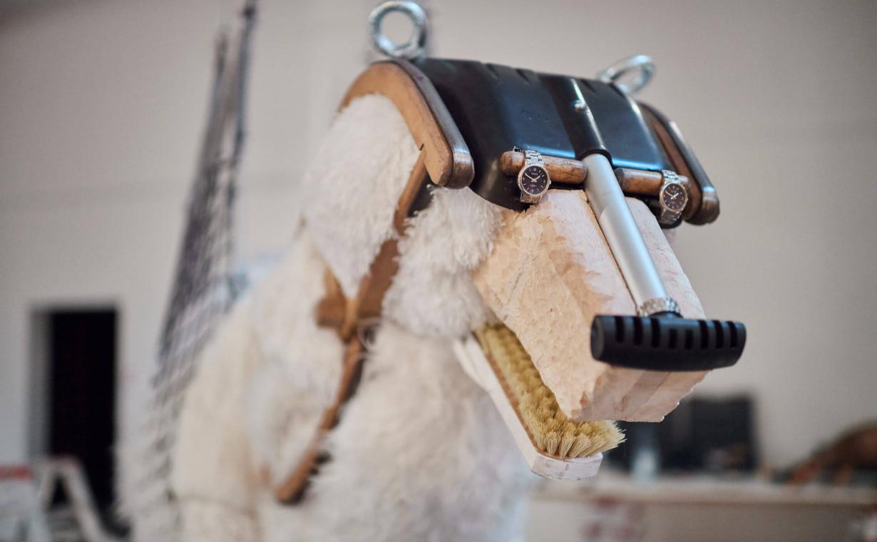 Ein Eisbär hängt in der Luft und ist mit einem Netz an der Holzkonstruktion der Arche befestigt. 