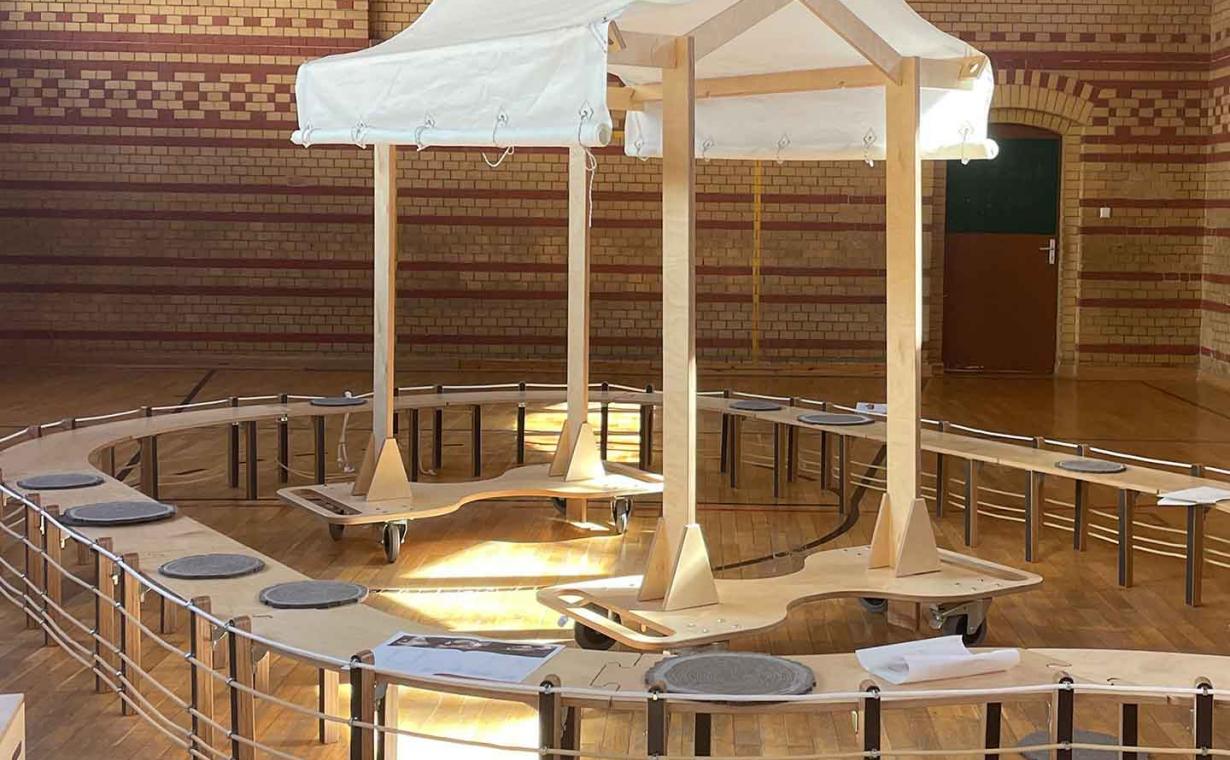 Aus Holzelementen zusammengesteckte Arche in einer Turnhalle.