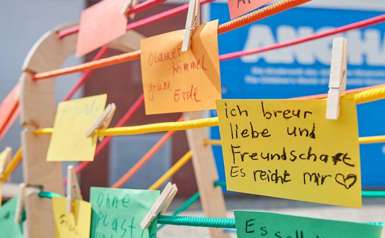 Bunte Wäscheleinen an denen bunte Zetteln mit Kinderschrift hängen.