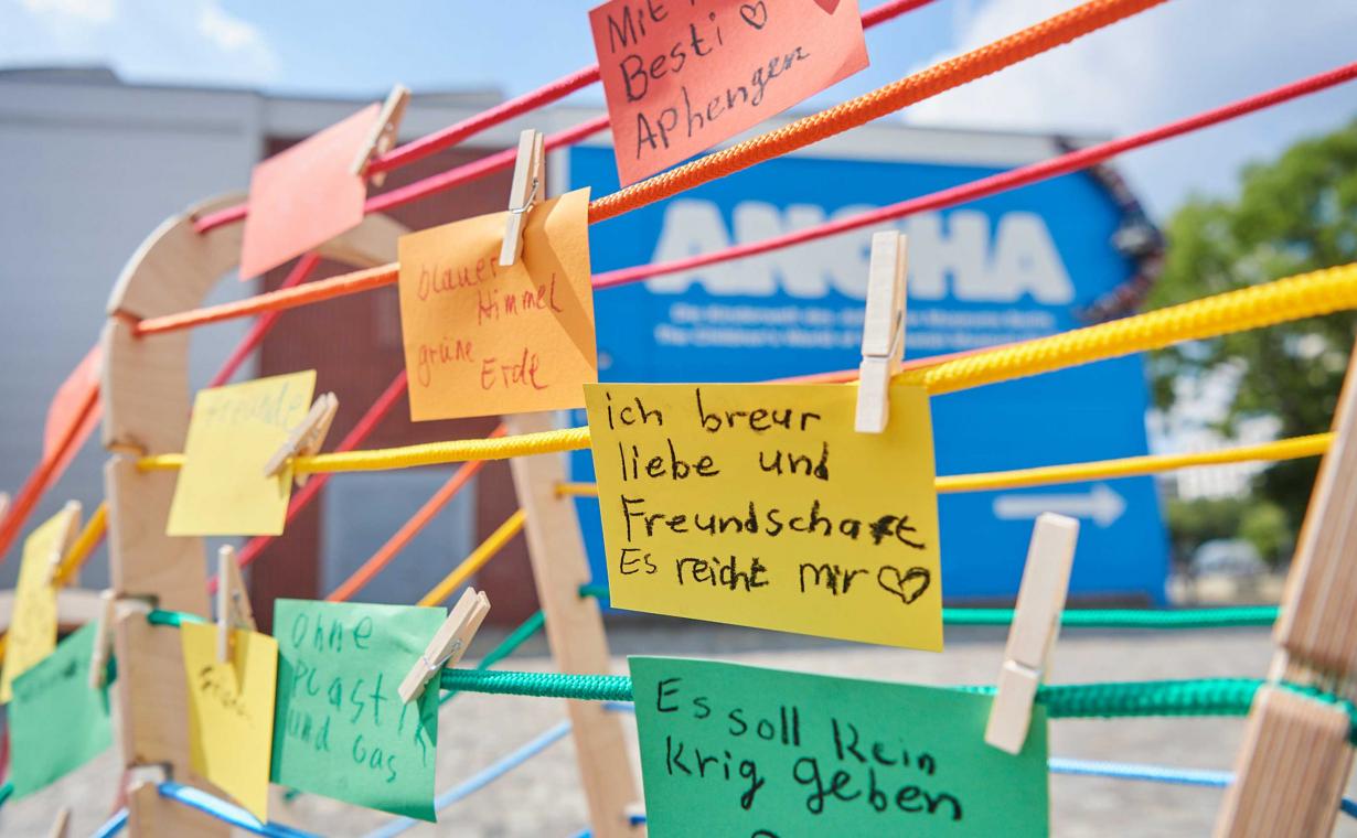 Bunte Wäscheleinen an denen bunte Zetteln mit Kinderschrift hängen.