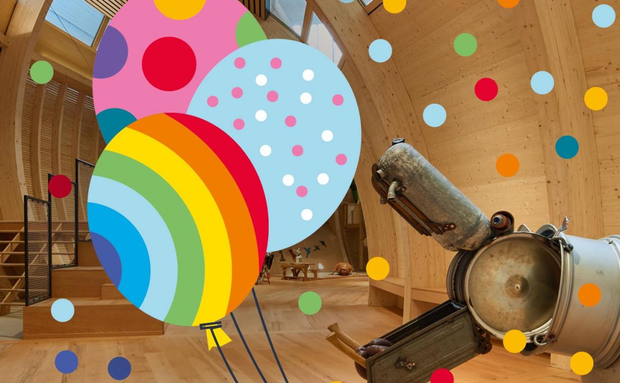 Eine Nilpferdskulptur im Kindermuseum reißt das Maul auf. Drumherum Konfetti und Ballons als Grafik.