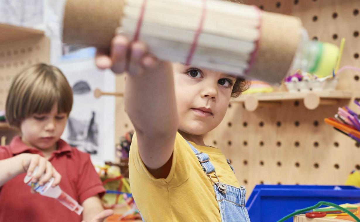 Zwei Kinder stehen an einer Werkbank.