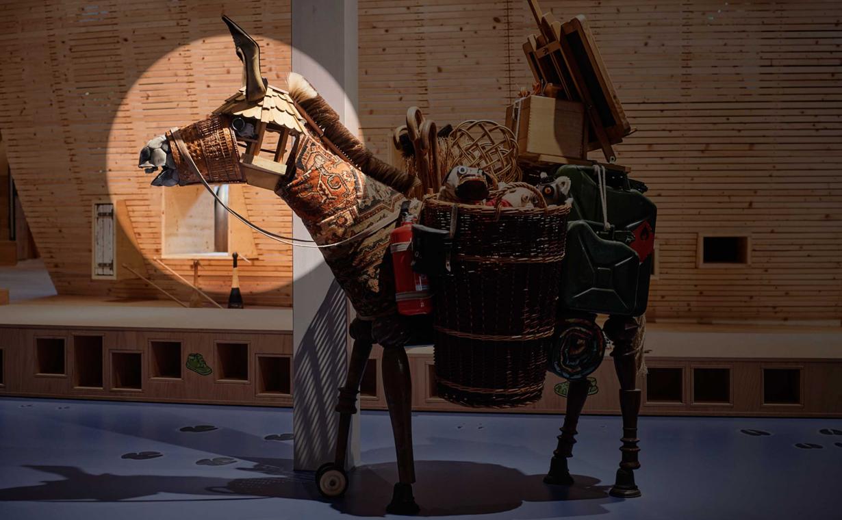 A donkey sculpture stands in the dark ANOHA, only the head is in the spotlight light.