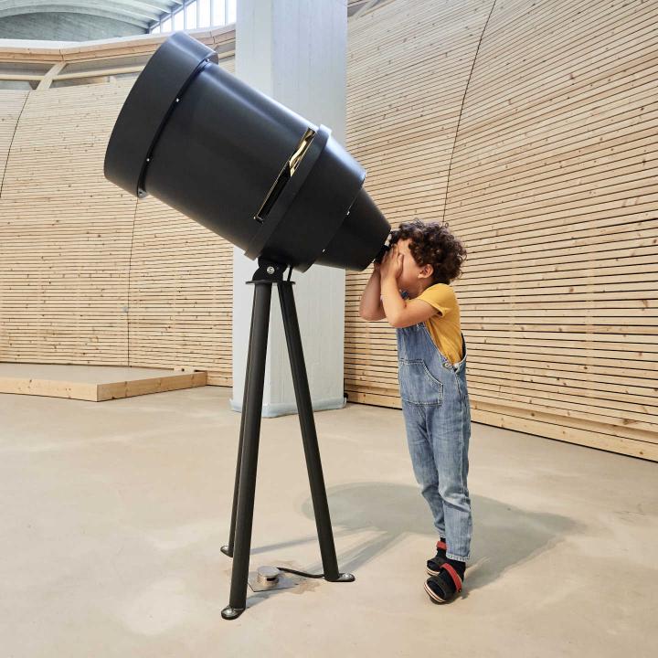 Child looks through telescope