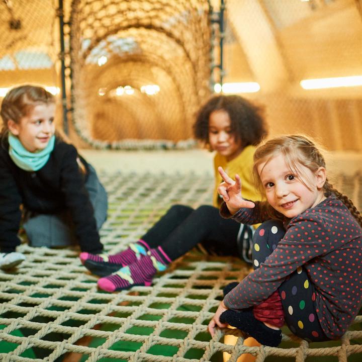 Three children sitting on a net