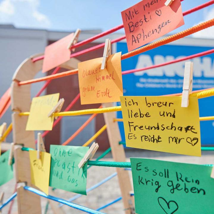 Colorful clotheslines on which hang colorful slips of paper with children's writing.