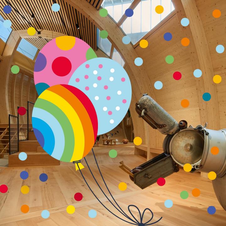 Eine Nilpferdskulptur im Kindermuseum reißt das Maul auf. Drumherum Konfetti und Ballons als Grafik.